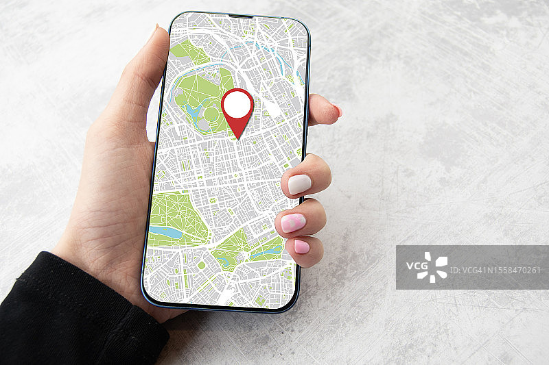 女人手持智能手机，屏幕上显示在线地图，英国图片素材