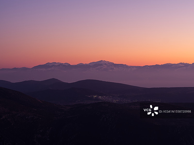 日落时群山映衬天空的剪影图片素材
