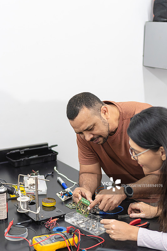男人教年轻大学生学习工程学图片素材