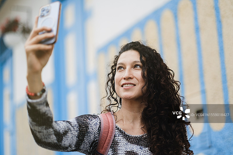 用手机拍照的拉丁裔女人图片素材