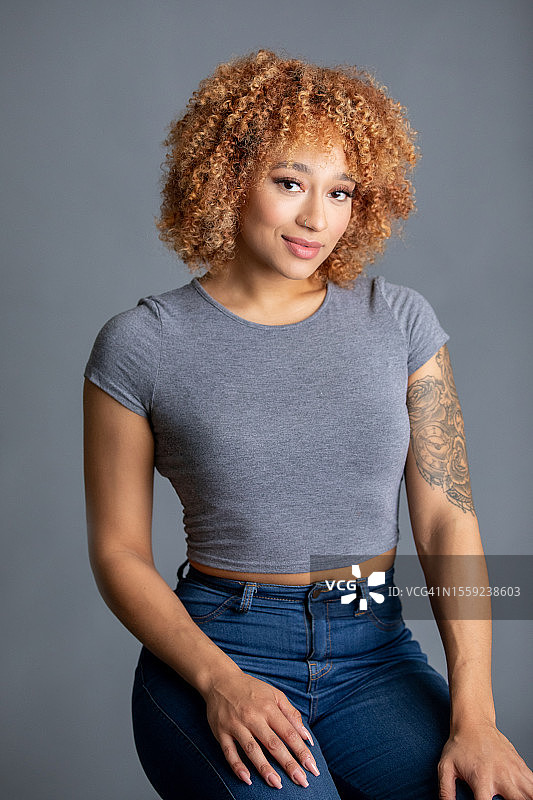 灰色背景下的前卫时尚模特肖像，有穿孔和纹身图片素材