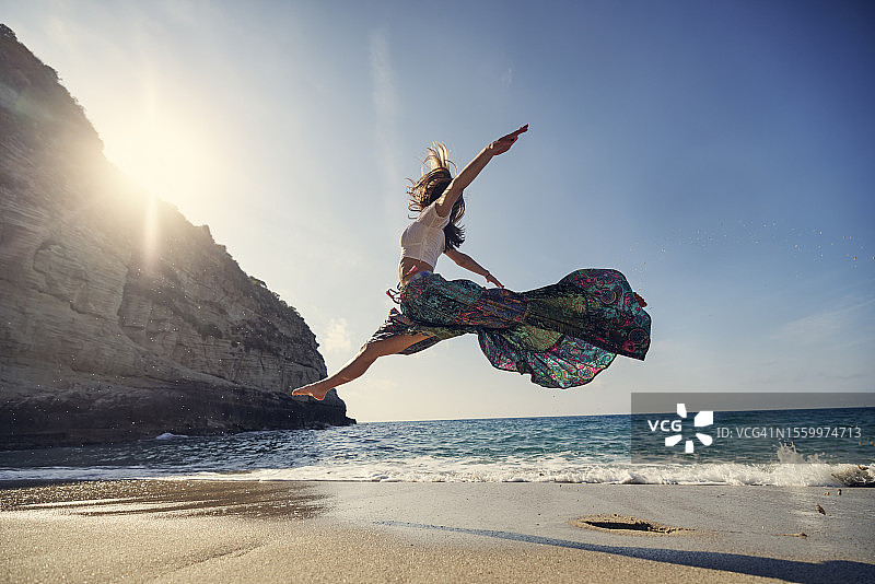 少女在美丽的海滩上跳舞图片素材