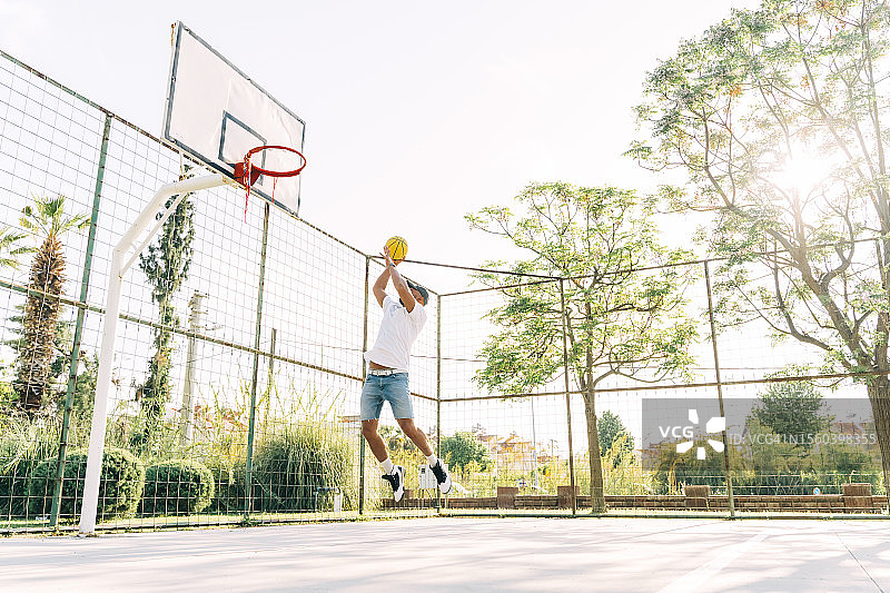 亚洲男人在运动场训练，投篮图片素材