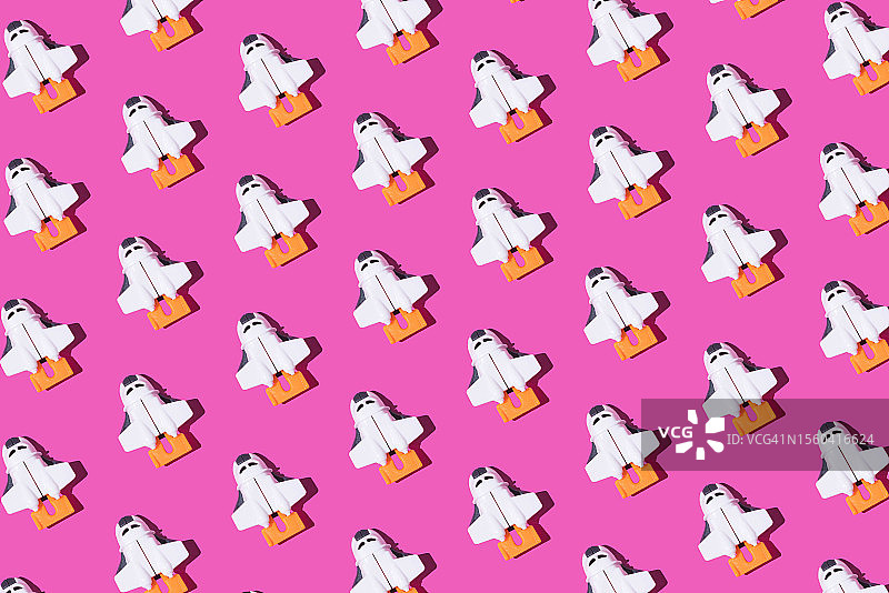 粉色背景上的玩具航天飞船图案，太空探索概念图片素材