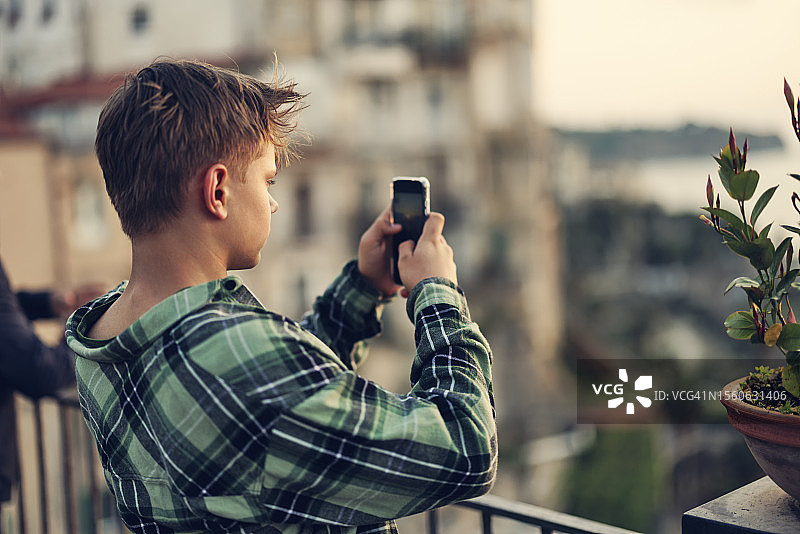 青少年男孩在迷人的特罗佩亚小镇拍摄美景图片素材