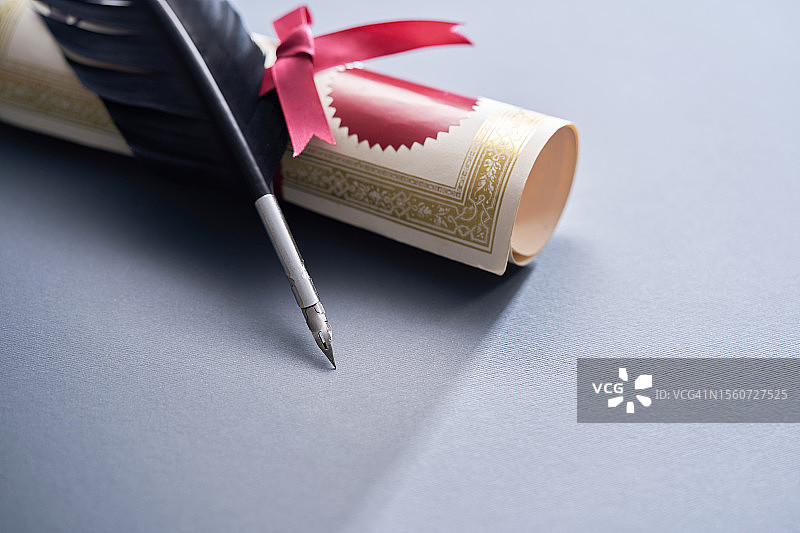 灰色背景上的一卷证书和羽毛笔，马来西亚图片素材