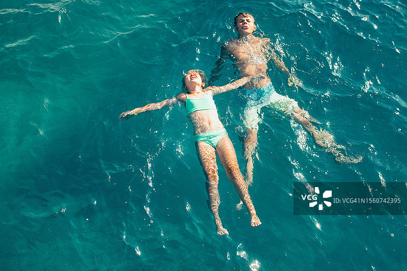 土耳其：俯视角度拍摄的在蓝绿色海水中游泳的儿童图片素材