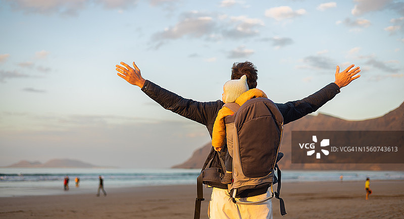 年轻的父亲张开双臂拥抱大自然图片素材