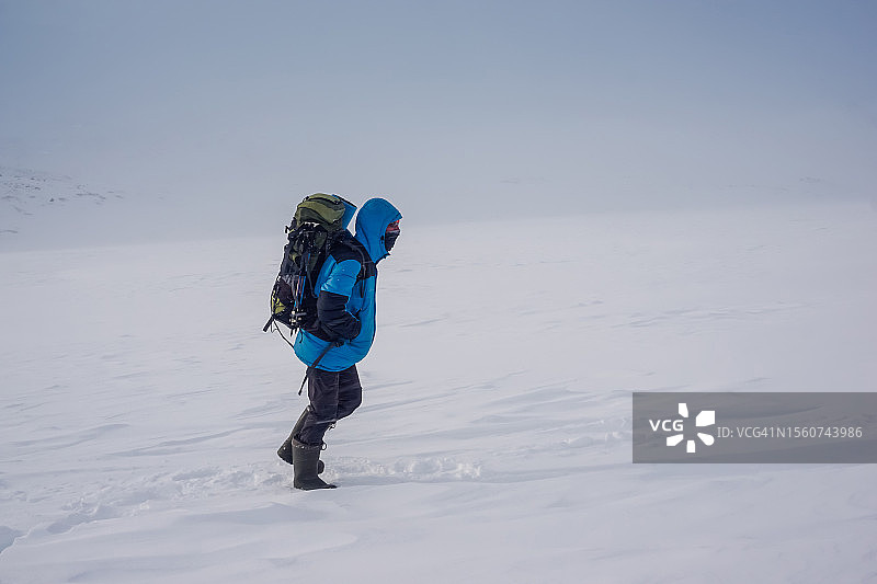 男子在俄罗斯堪察加边疆区雪地行走的侧视图图片素材