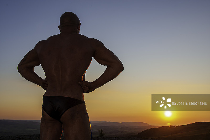 英格兰萨默塞特郡日落下的男性健美运动员图片素材