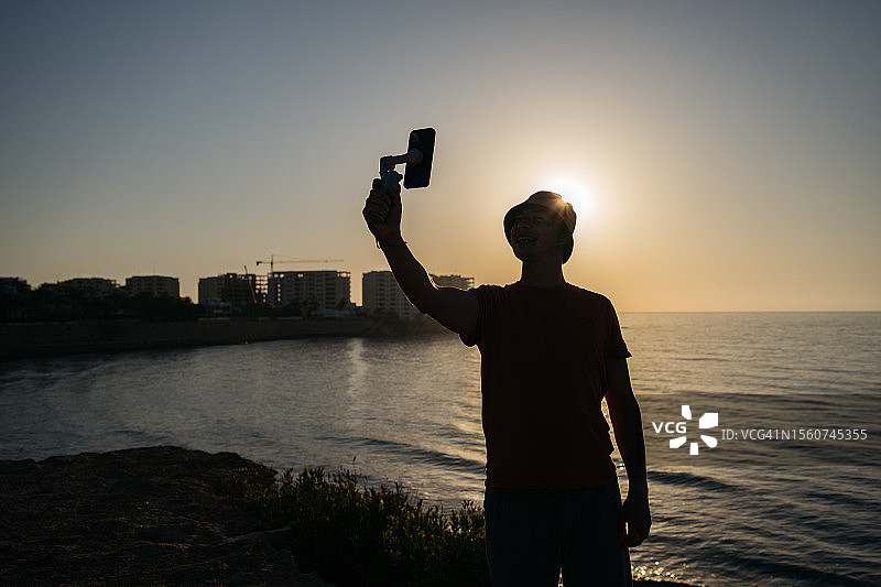 男人剪影日出时拍自拍图片素材