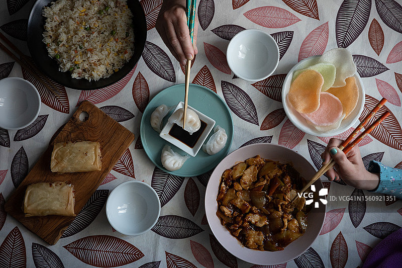 俯瞰：两人用筷子夹中国美食图片素材