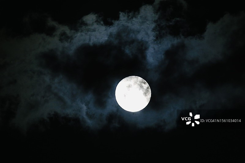乌云密布的黑暗天空中的满月图片素材