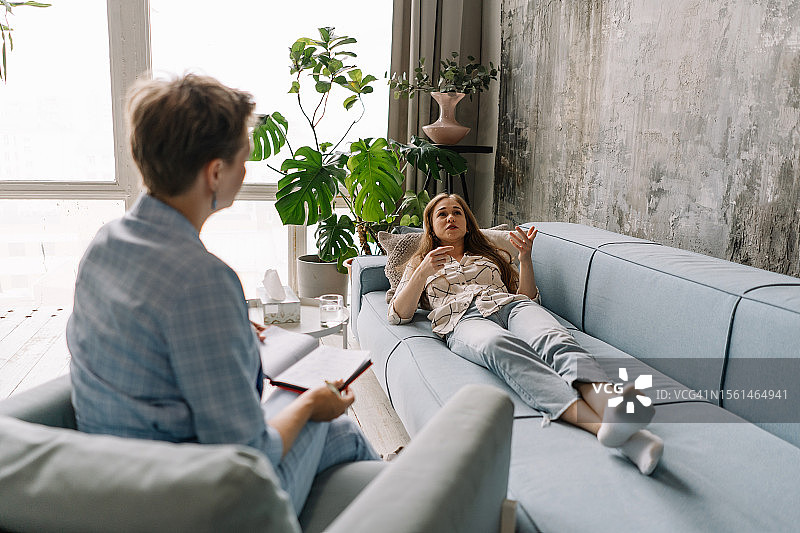 年轻女子与心理医生进行心理治疗，获得创伤和心理健康支持图片素材