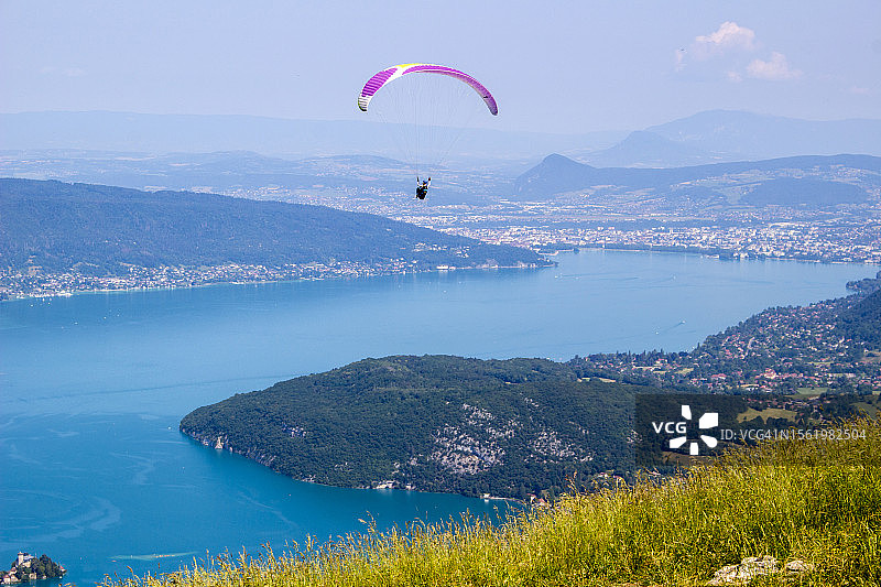 从法国塔卢瓦尔-蒙特明看到的阿讷西湖上空的滑翔伞图片素材