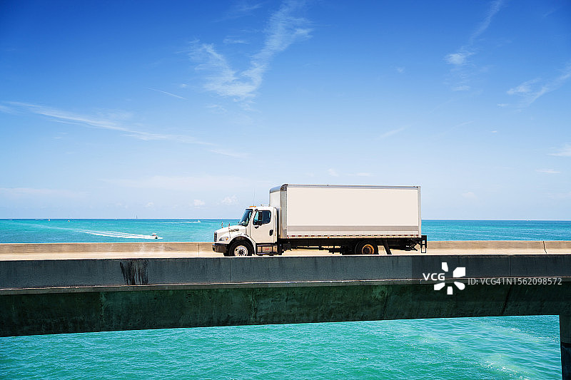 白色送货卡车行驶在佛罗里达马拉松七英里大桥上图片素材