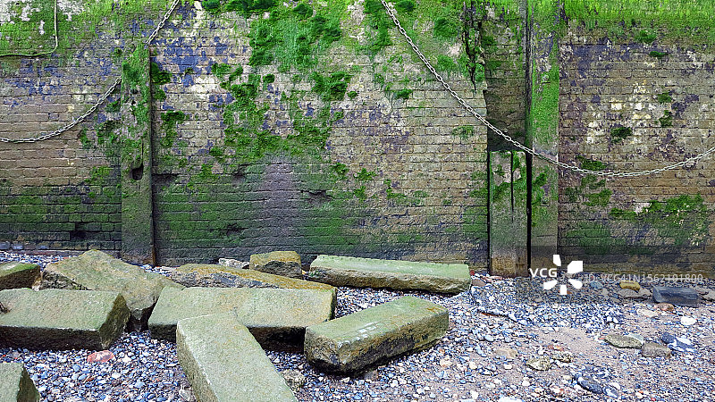 伦敦码头（英国）被藻类和绿色苔藓覆盖的风化砖砌挡土墙图片素材