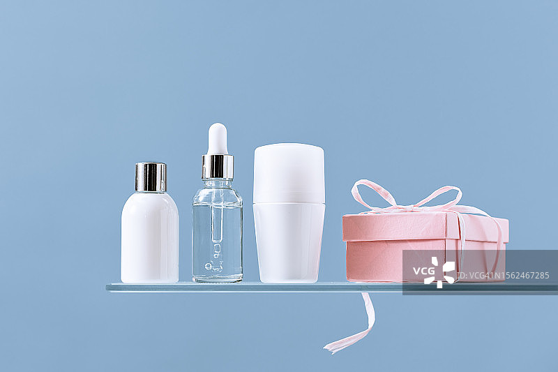 玻璃置物架上的礼品盒、化妆品和美妆产品样机图片素材