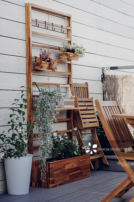 阳光明媚的夏日，屋顶露台上带有花园家具和植物的舒适空间图片素材
