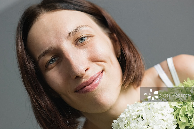 手持绣球花的年轻女子肖像图片素材