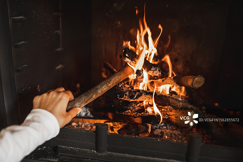 女人将木柴扔进壁炉里图片素材