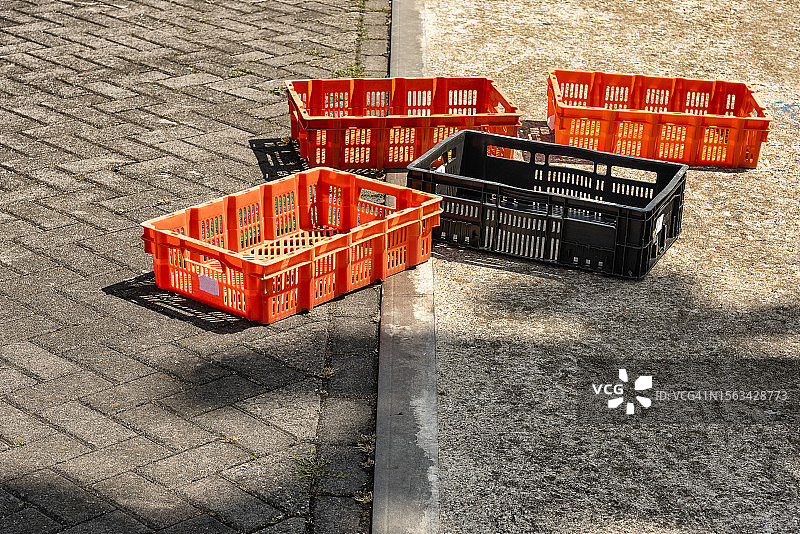 三个橙色和一个黑色塑料箱图片素材