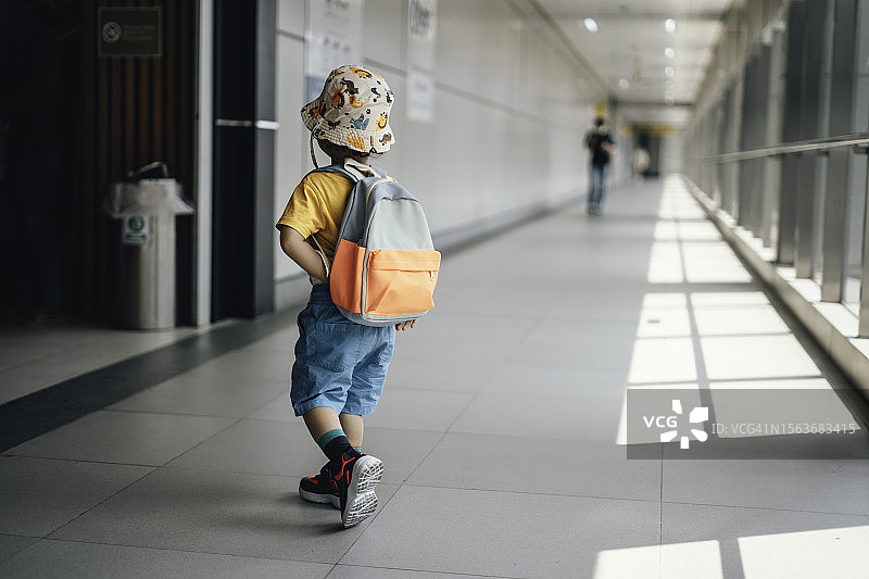 背着书包在城市人行天桥上行走的小学生图片素材
