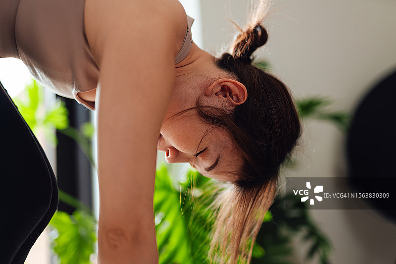 专注于在家练习瑜伽的年轻女子肖像图片素材