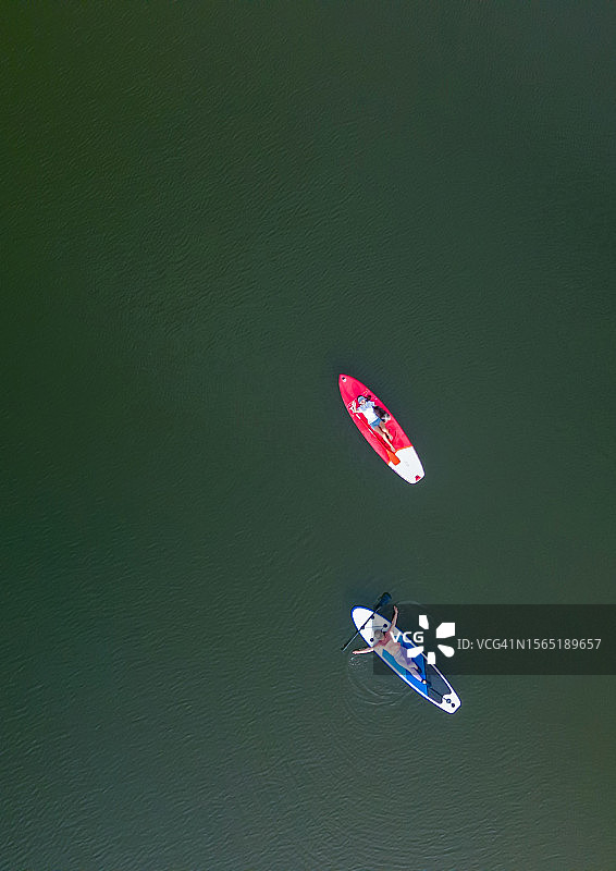 亚洲女子在泰国湖上与朋友一起划桨板的航拍图片素材