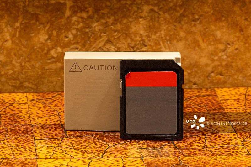金色图案盒上的SD卡和相机电池图片素材