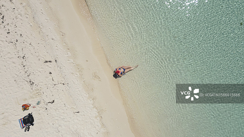 鸟瞰：女人在海边浅水区放松图片素材