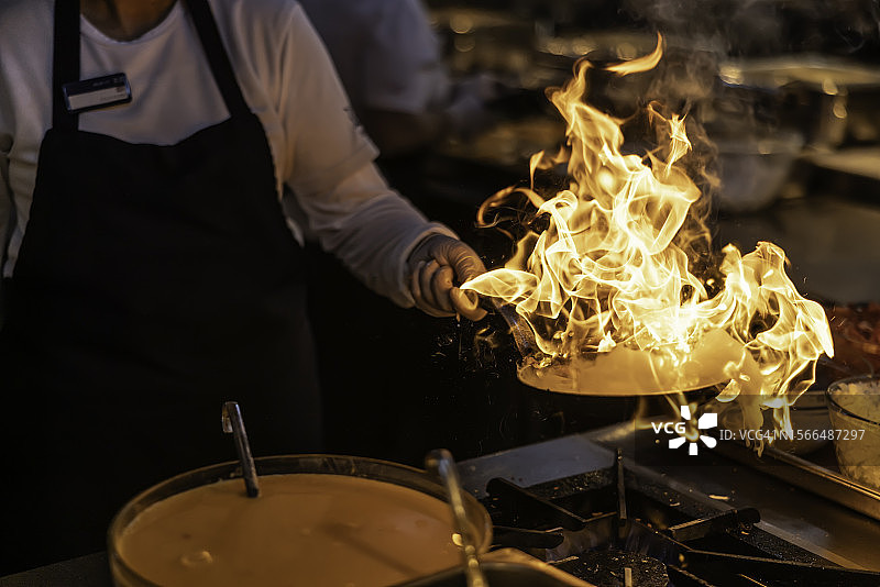 专业厨师在燃气灶的平底锅中烹饪图片素材