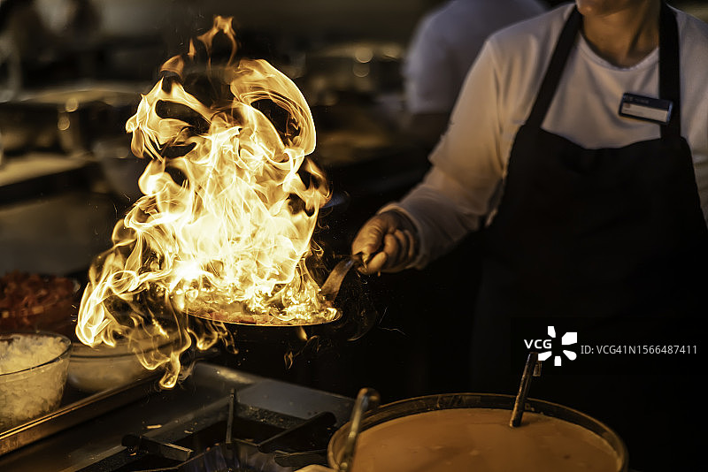 专业厨师在燃气灶的平底锅中烹饪图片素材