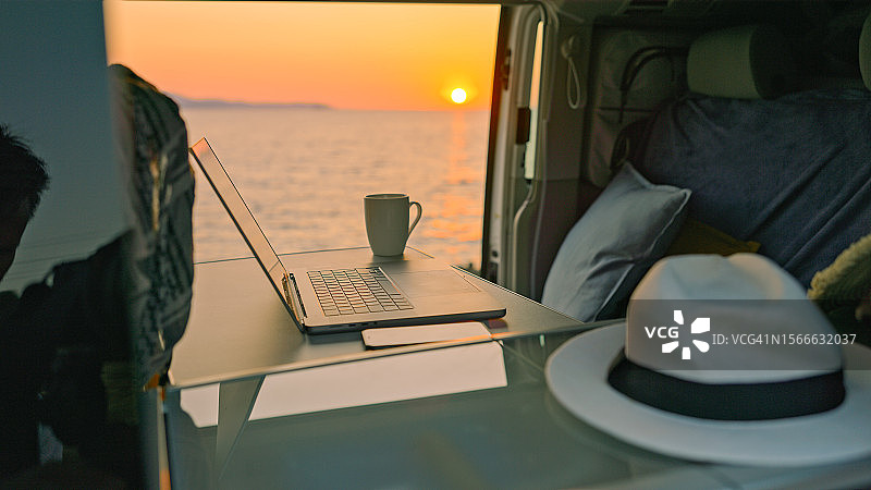 带笔记本电脑和海景的露营车内景图片素材