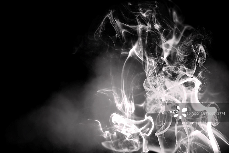 黑暗背景中神秘面纱中旋转的空灵烟雾图片素材