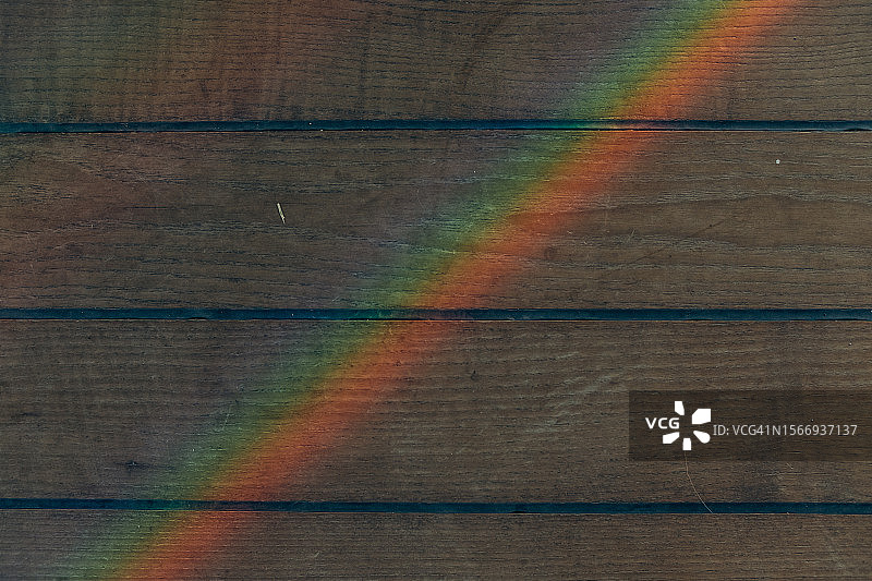 木质背景上的彩色彩虹图片素材