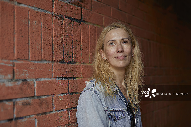 砖墙自然光下的白人女士肖像图片素材