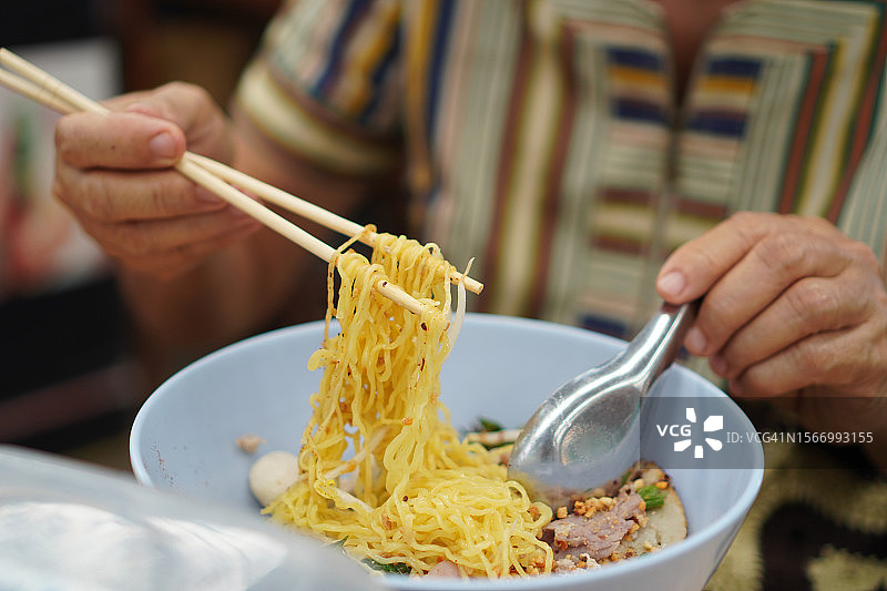筷子夹着的猪肉鸡蛋面和猪肉丸图片素材