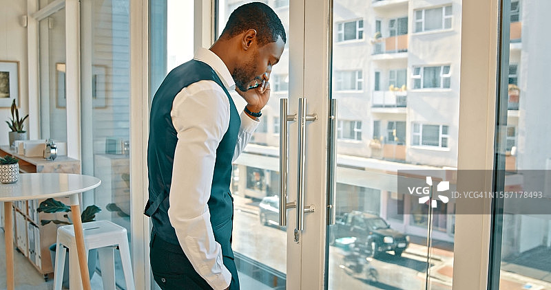 黑人男子在办公室窗口边打电话洽谈商务合作图片素材
