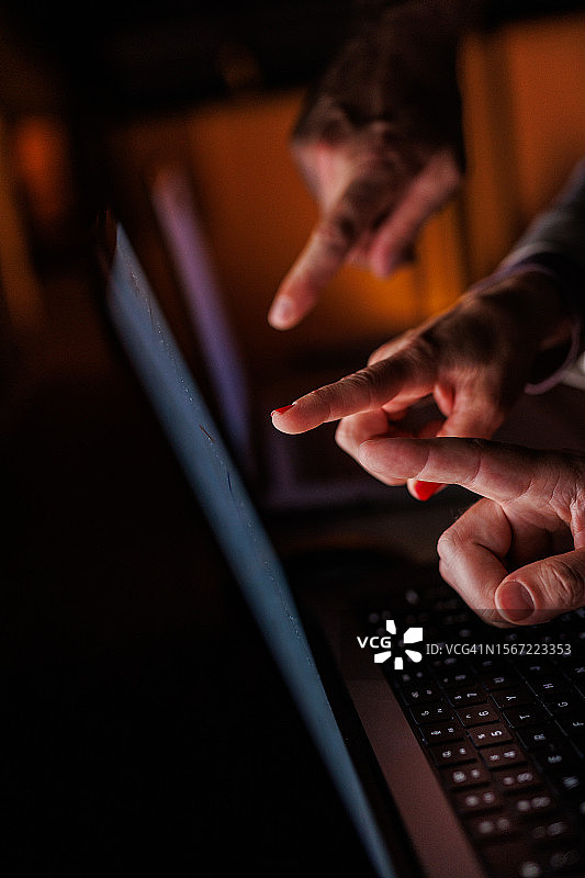 商务人士指向笔记本电脑屏幕上的数据图片素材