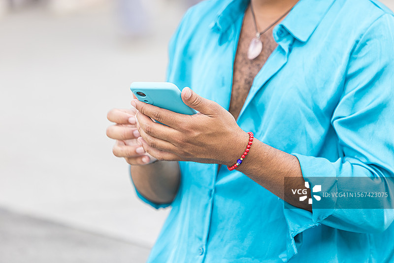 在城市里看手机的拉丁裔男人图片素材