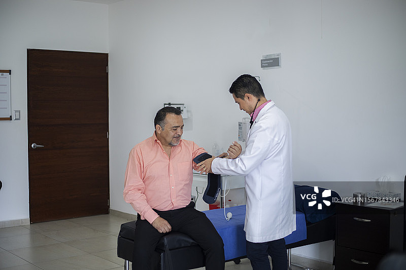 心脏病专家为成年男性患者提供咨询图片素材