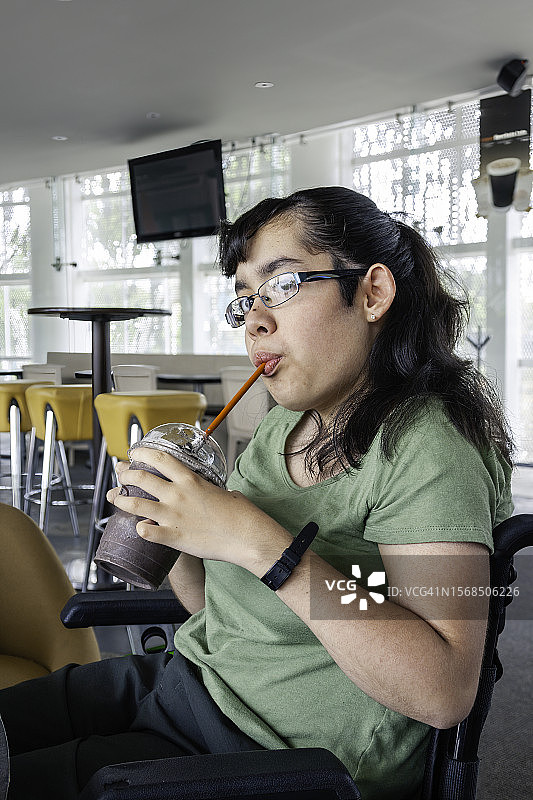 正在喝冷饮的残疾女孩图片素材