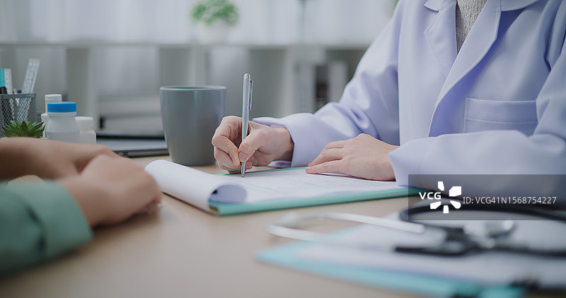 亚洲女医生与病人讨论体检结果图片素材