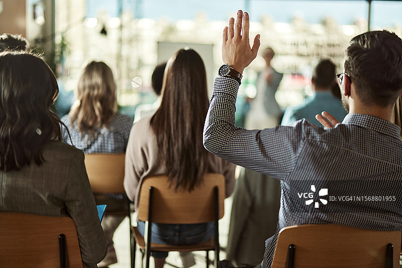 商务男士在研讨会上举手发言背影图片素材