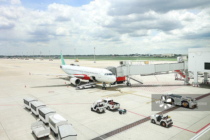 飞机起飞前的准备，飞机停靠在廊桥背景图片素材