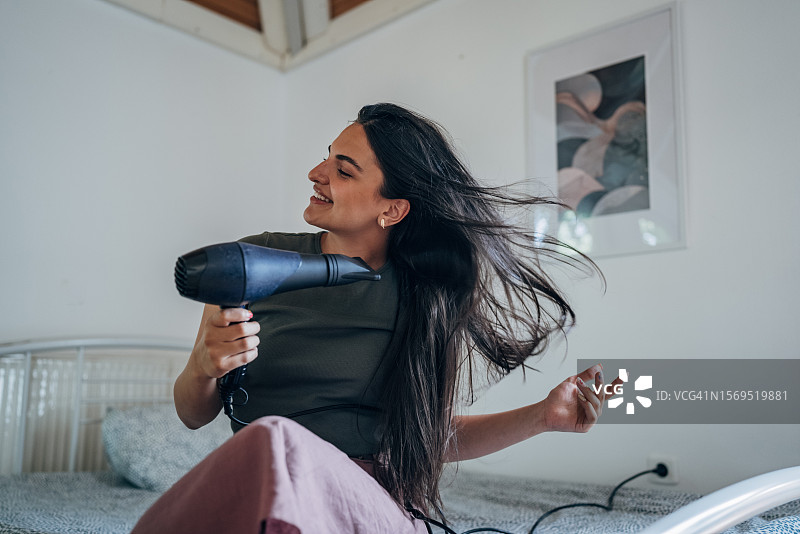 女人使用吹风机图片素材