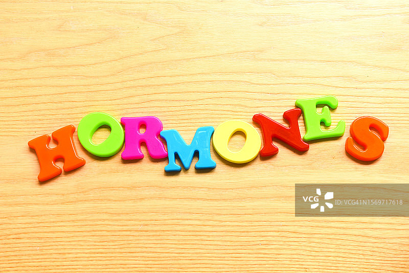 木质背景上的“荷尔蒙”字样图片素材