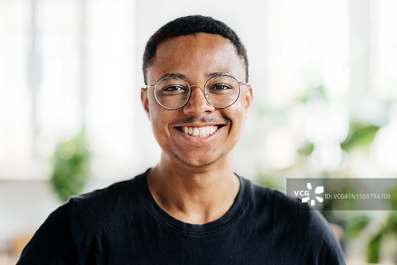 戴眼镜的微笑年轻研讨会参与者肖像图片素材