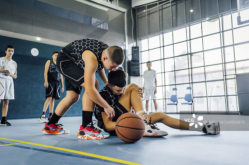 青少年篮球运动员在比赛中受伤图片素材